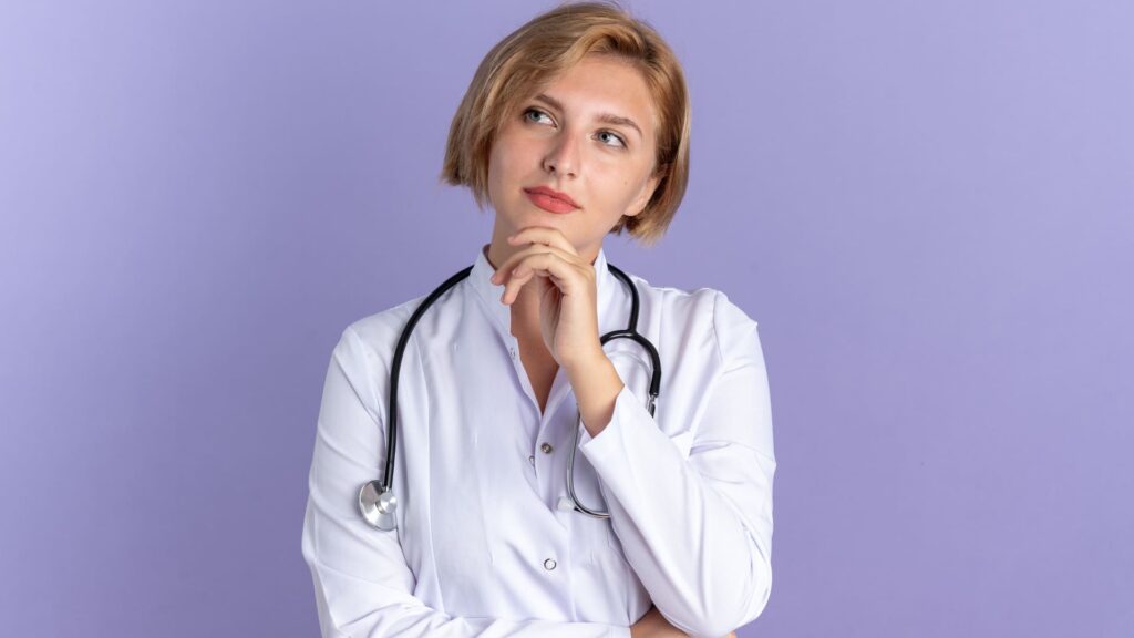 Medico che riflette con la mano sulla fronte