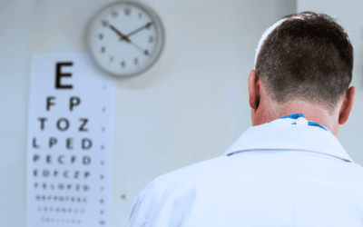 An ophthalmologist stands with his back to a clock, symbolizing the need to reduce waiting times at the ophthalmology clinic.