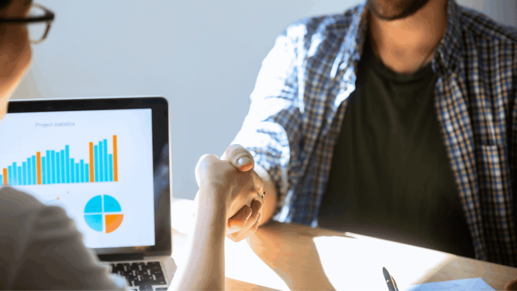 Zahnarzt, der einem anderen Zahnarzt nach dem Kauf seiner Zahnarztpraxis die Hand schüttelt