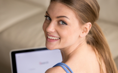 A smiling patient behind her computer after a teledermatology session.